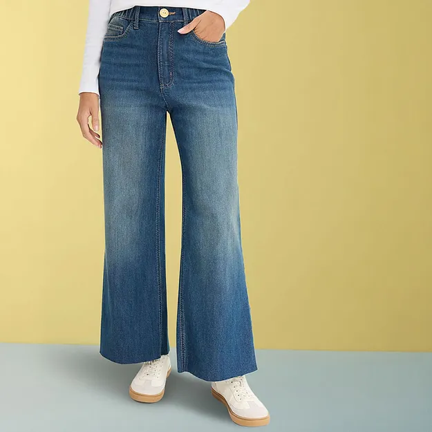 Weite Jeans mit wei&szlig;em Oberteil und hellen Sneakers.