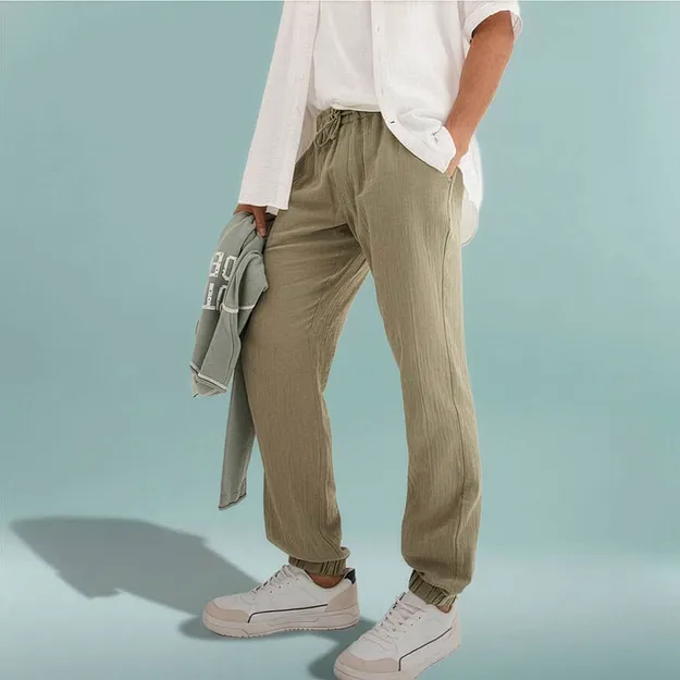 Entspannte olivgr&uuml;ne Hose mit wei&szlig;em Oberteil und hellem Sweatshirt.
