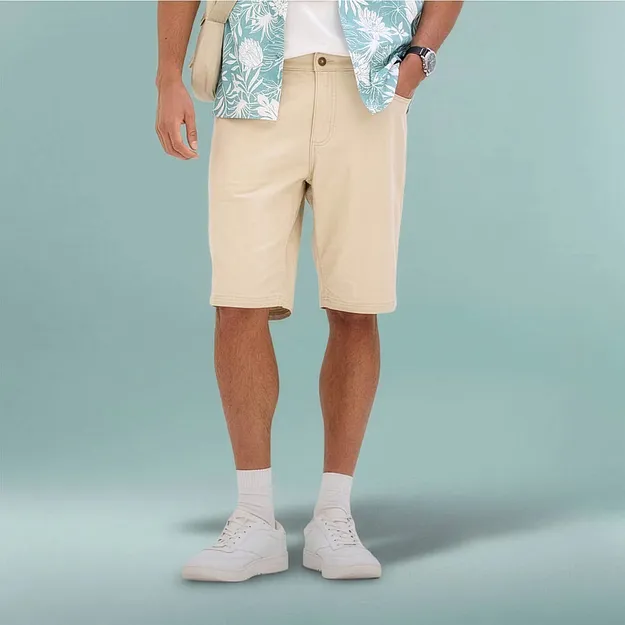L&auml;ssiges Sommeroutfit mit beiger Bermuda-Shorts, gemustertem Hemd und wei&szlig;en Sneakers.