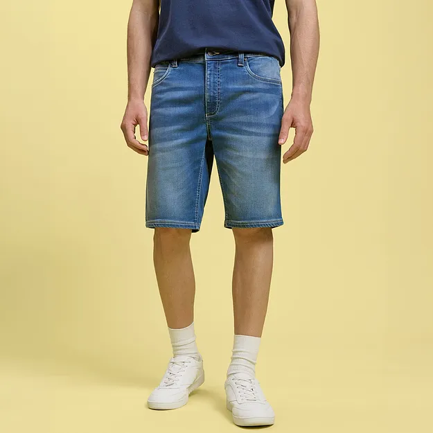 Short en jean d&eacute;contract&eacute; et T-shirt bleu associ&eacute; &agrave; des tennis et des chaussettes blanches.