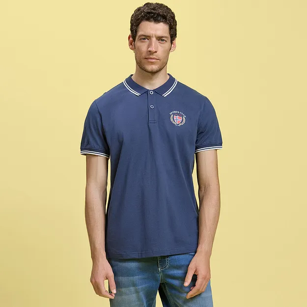 Polo bleu sportif avec logo associ&eacute; &agrave; un short en jean d&eacute;contract&eacute;.
