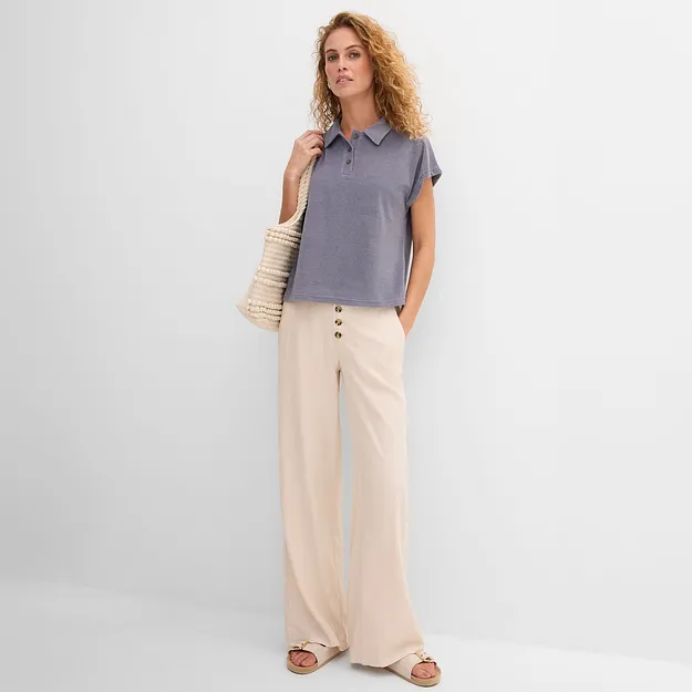 Elegante Frau tr&auml;gt blaues lockeres T-Shirt und weite beige Hose im l&auml;ssigen Stil.