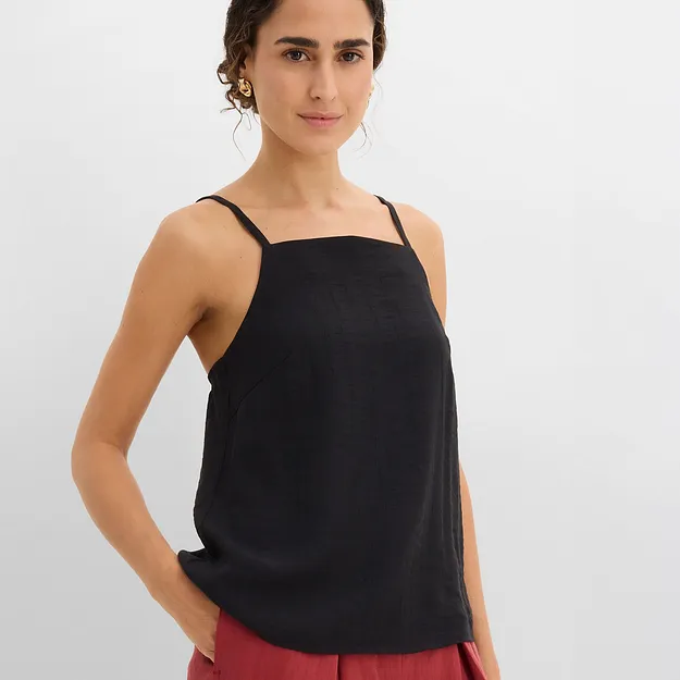 Schwarzes Top kombiniert mit einer roten weiten Hose f&uuml;r einen l&auml;ssigen Look.