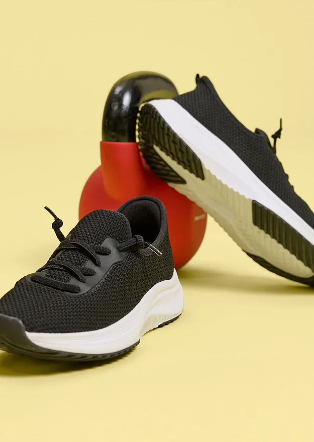 Schwarze Sportschuhe mit wei&szlig;er Sohle.