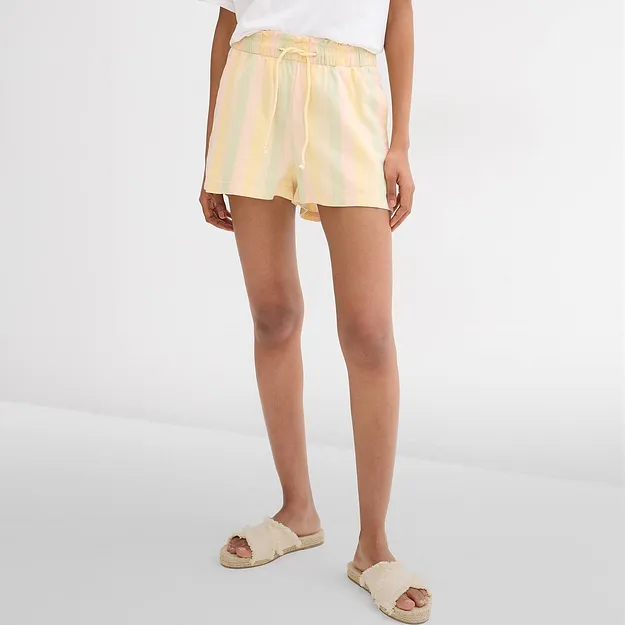 Short pastel ray&eacute;, T-shirt blanc et sandales en raphia confortables pour les chaudes journ&eacute;es.