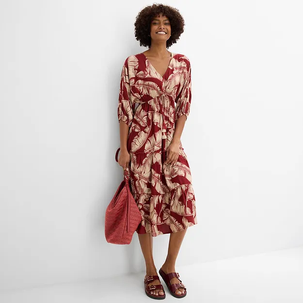 Luftiges Midikleid mit Blattmuster, dazu passende Tasche und rote Sandalen.
