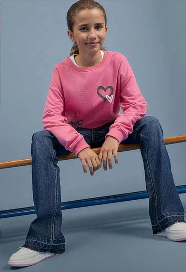 Modisches Outfit: rosa Langarmshirt mit Herz, weite Jeans und bequeme wei&szlig;e Sneaker.