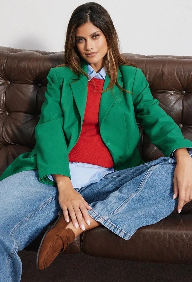 Gr&uuml;ner Blazer, rotes Shirt, blaues Hemd, weite Jeans und braune Slipper.