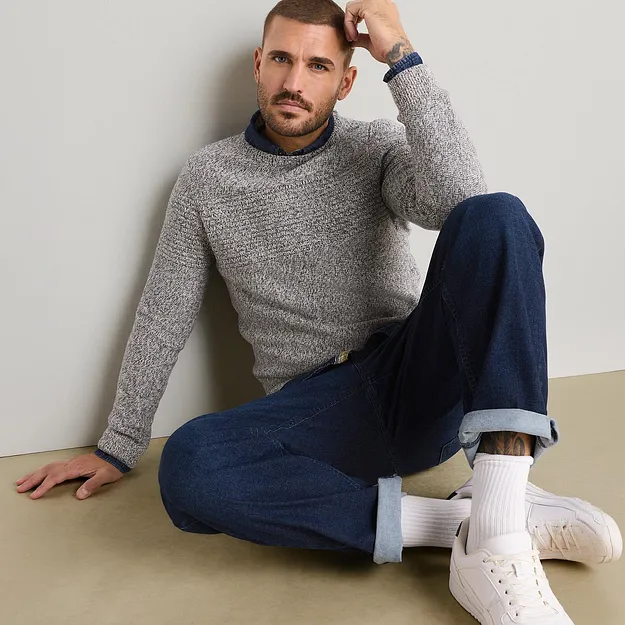 Pull en maille chin&eacute;e, chemise bleue et jean, dans un esprit d&eacute;contract&eacute;-chic.
