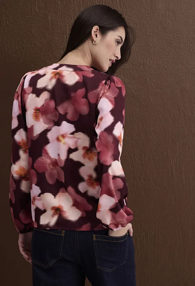 Dunkelrote Blumenbluse mit zarten Bl&uuml;ten, kombiniert mit klassischen blauen Jeans.
