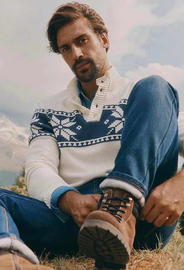 Ein gem&uuml;tlicher Fair-Isle-Pullover, Jeans und robuste braune Wanderstiefel im Freien.