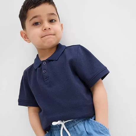 Ein dunkelblaues Poloshirt kombiniert mit hellblauen Jeans.