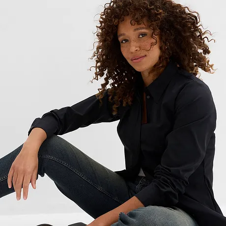 Ein lässiger Look mit schwarzem Hemd und dunkler Jeans.