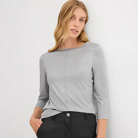 Schlichtes graues Shirt mit Dreiviertelärmeln, zeitlos elegant kombiniert mit einer dunklen Hose.
