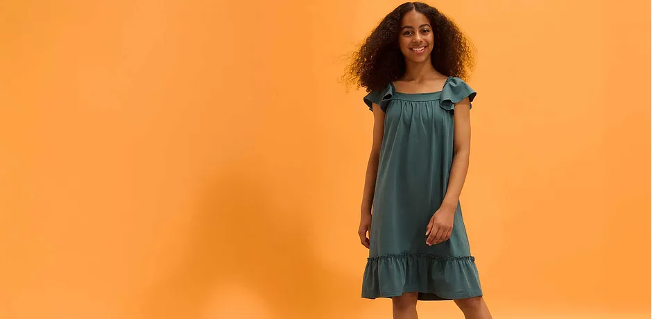 Sommerliches grünes Kleid mit Rüschen und Volants. Kurze Ärmel und luftiger Schnitt.