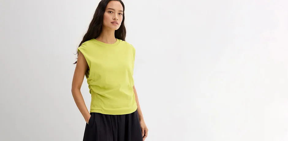 Un T-shirt couleur citron vif avec une jupe fluide foncée.