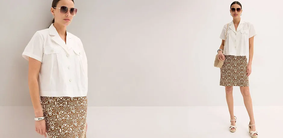 Tenue d’été avec un chemisier blanc et une jupe à motifs. Complétée par des lunettes de soleil, des sandales et un sac en paille.
