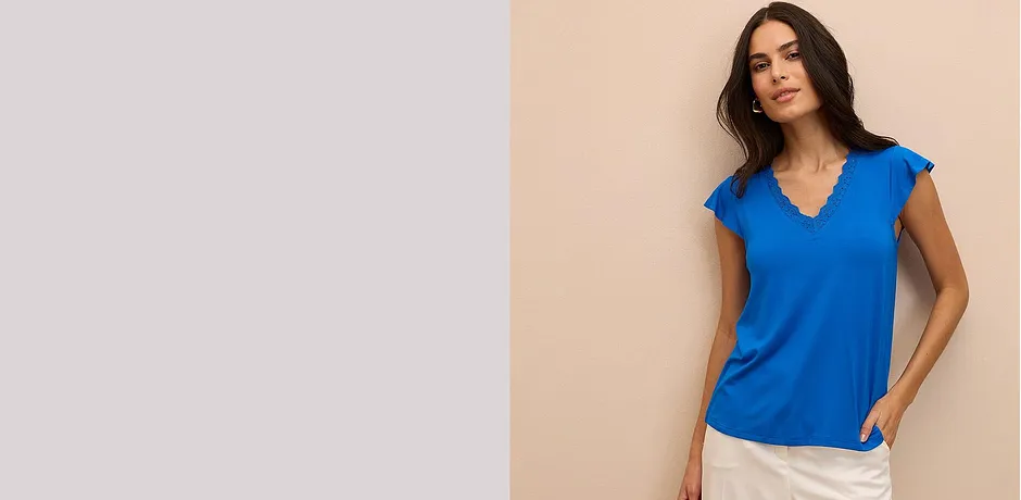 Leuchtend blaues Top mit V-Ausschnitt und kurzen Ärmeln, kombiniert mit heller Hose.