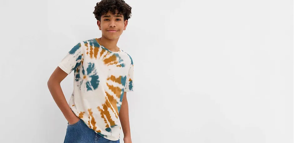T-shirt batik moderne en bleu et orange, associé à un jean classique pour un look décontracté. 
