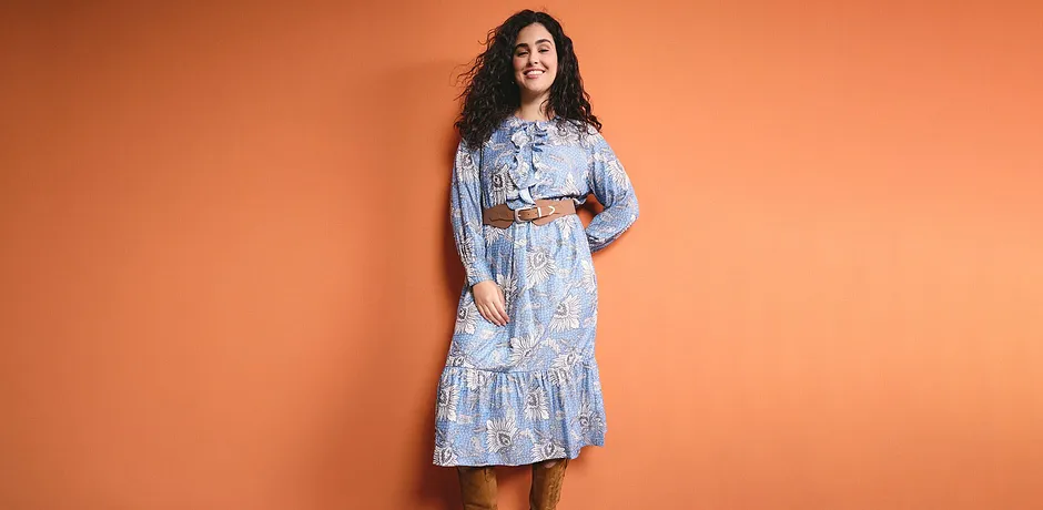 Robe à fleurs bleu clair avec manches longues, volants et ceinture. Un style léger et estival pour les chaudes journées.