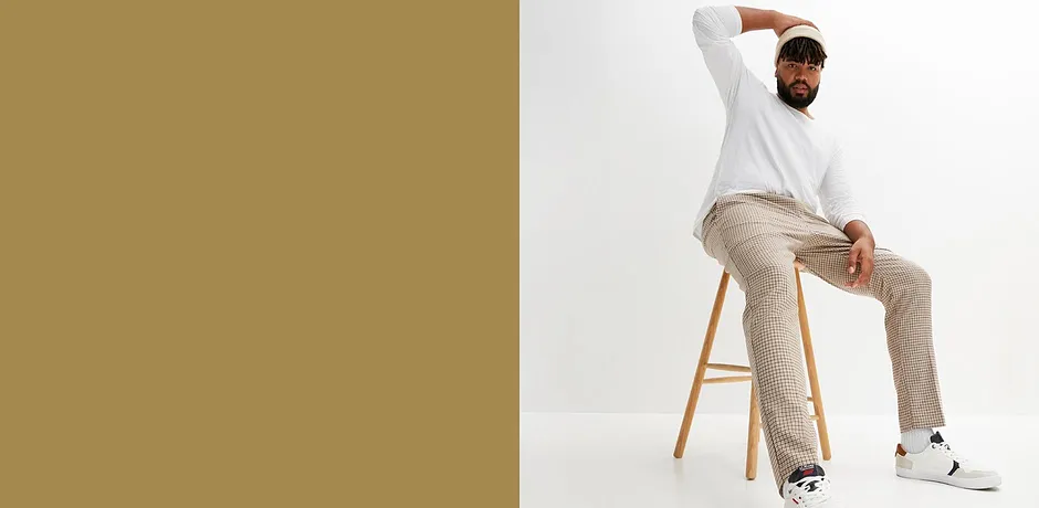 Weißes Langarmshirt, beige Hose und weiße Sneakers bilden einen lässigen, stilvollen Look.