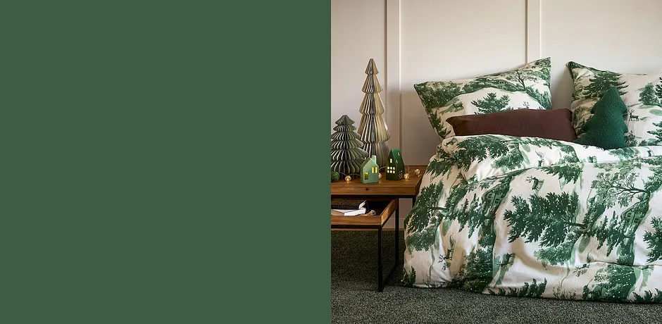 Parure de lit avec sapins en vert et blanc pour une ambiance chaleureuse dans la chambre.