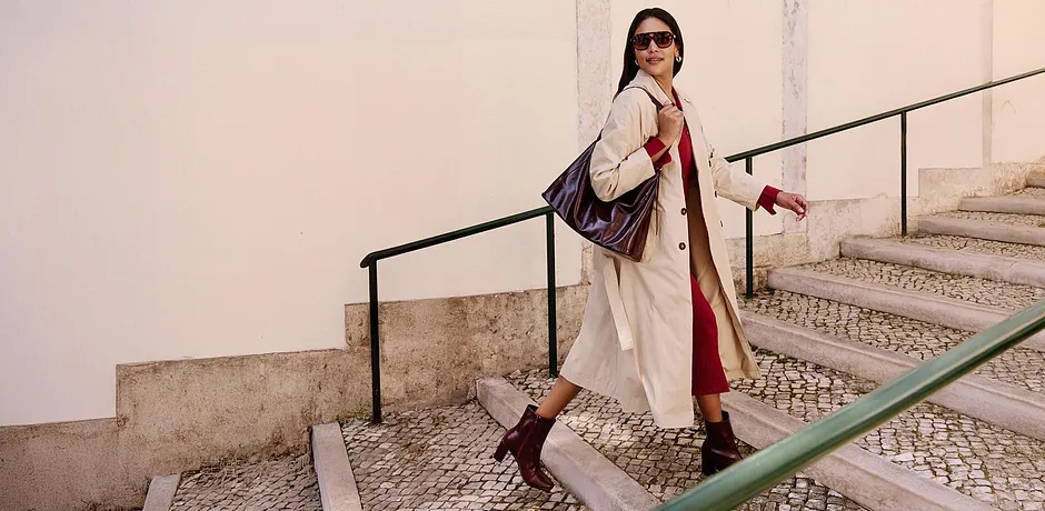 Trench-coat élégant, touches de rouge et bottines stylées. Un look urbain et chic.