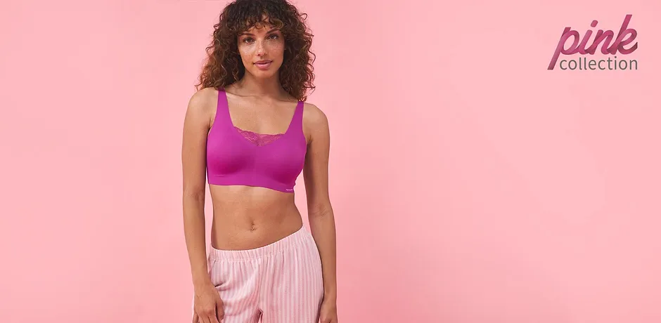 Sportliches Outfit: Lila Crop-Top und gestreifte rosa Hose. Perfekt für Fitness und Freizeit.