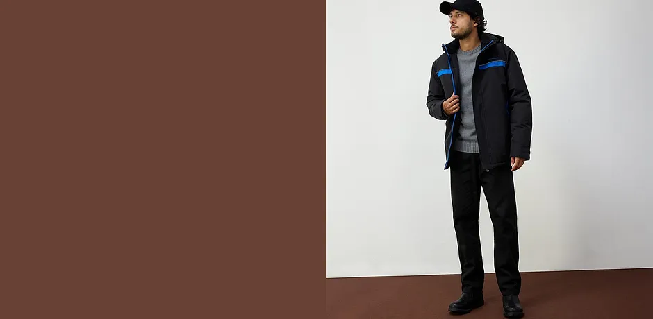 Veste d'hiver sportive en coloris noir avec des touches de bleu, complétée d'un T-shirt gris et d'un pantalon noir.