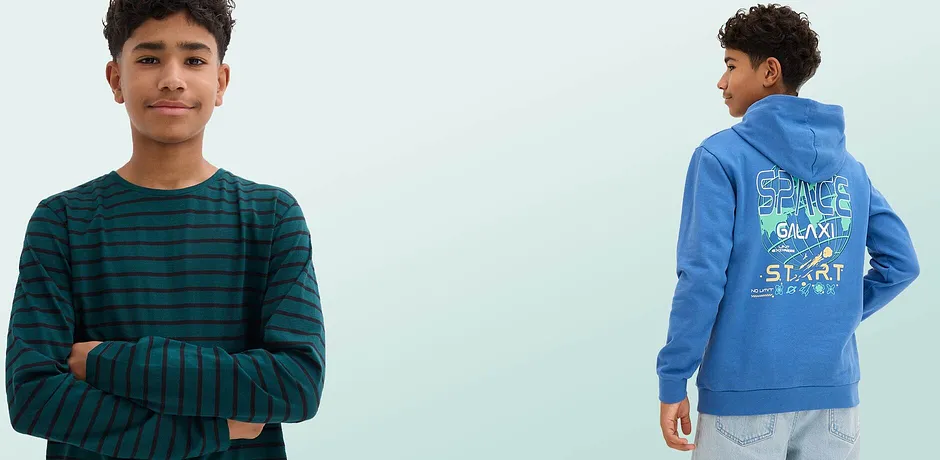 Un T-shirt rayé vert et noir à manches longues et un pull bleu à capuche avec un imprimé spatial coloré dans le dos.