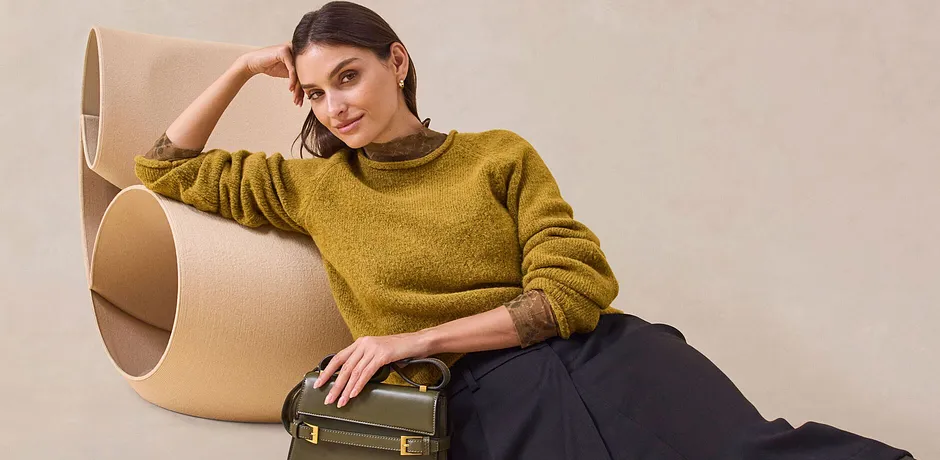 Pull chaud jaune moutarde et jupe noire élégante.