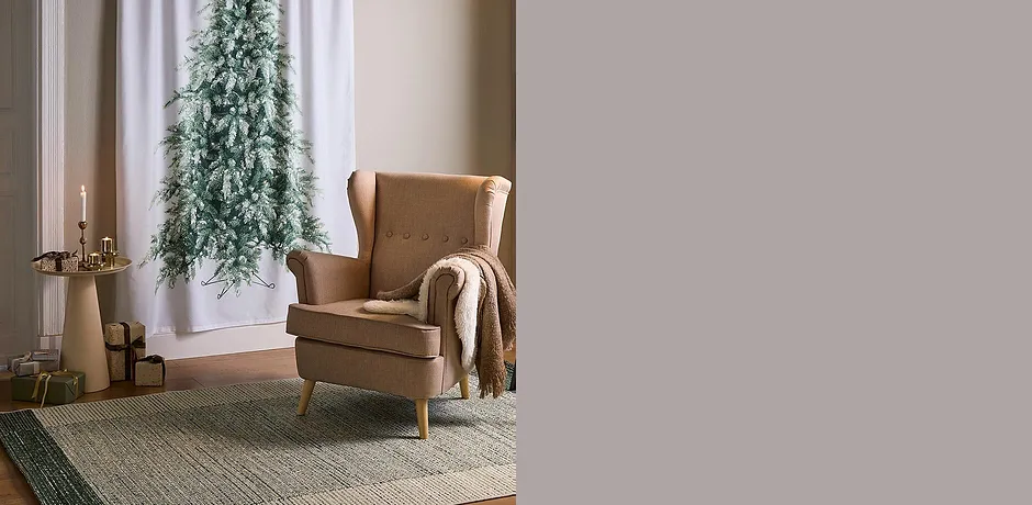 Fauteuil cosy avec plaid en laine. Un tapis et des bougies finalisent l'atmosphère chaleureuse.