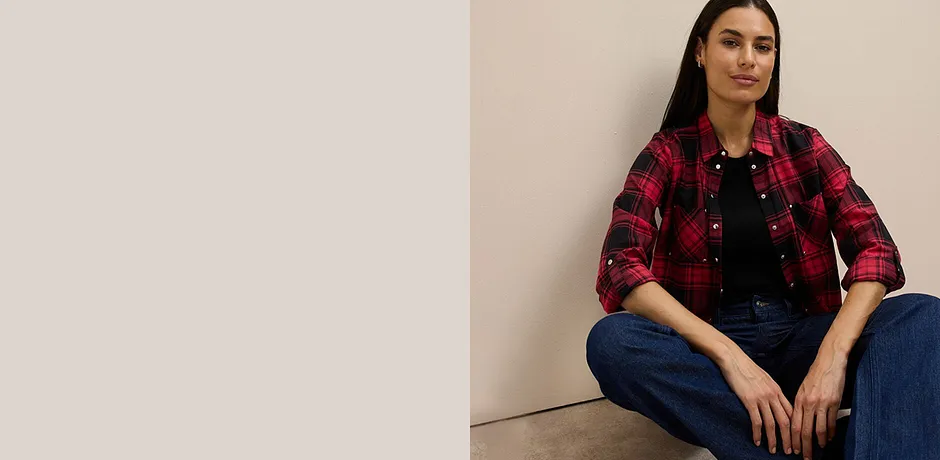 Chemise à carreaux rouge et noir sur un top noir, portée avec un jean classique.