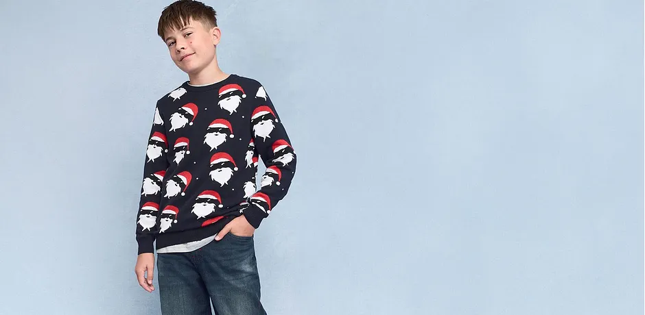 Pull de Noël avec motifs Père Noël associé à un jean décontracté. 
