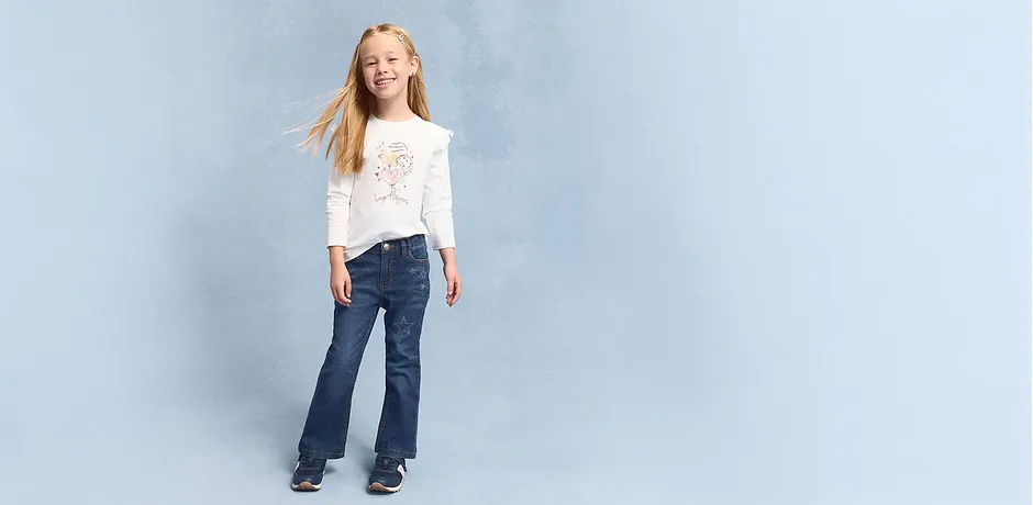 Look décontracté avec un T-shirt blanc à manches longues et un jean évasé.
