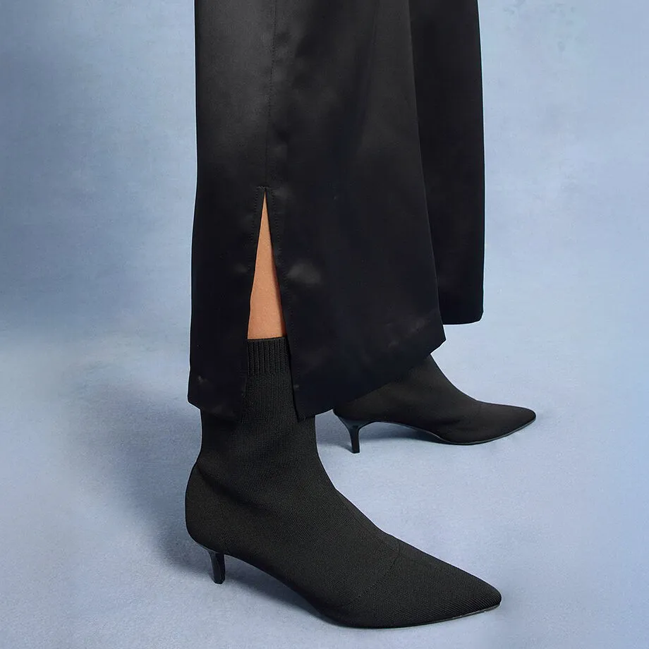 Elegante schwarze Hose mit Schlitz, kombiniert mit spitzen Stiefeletten.