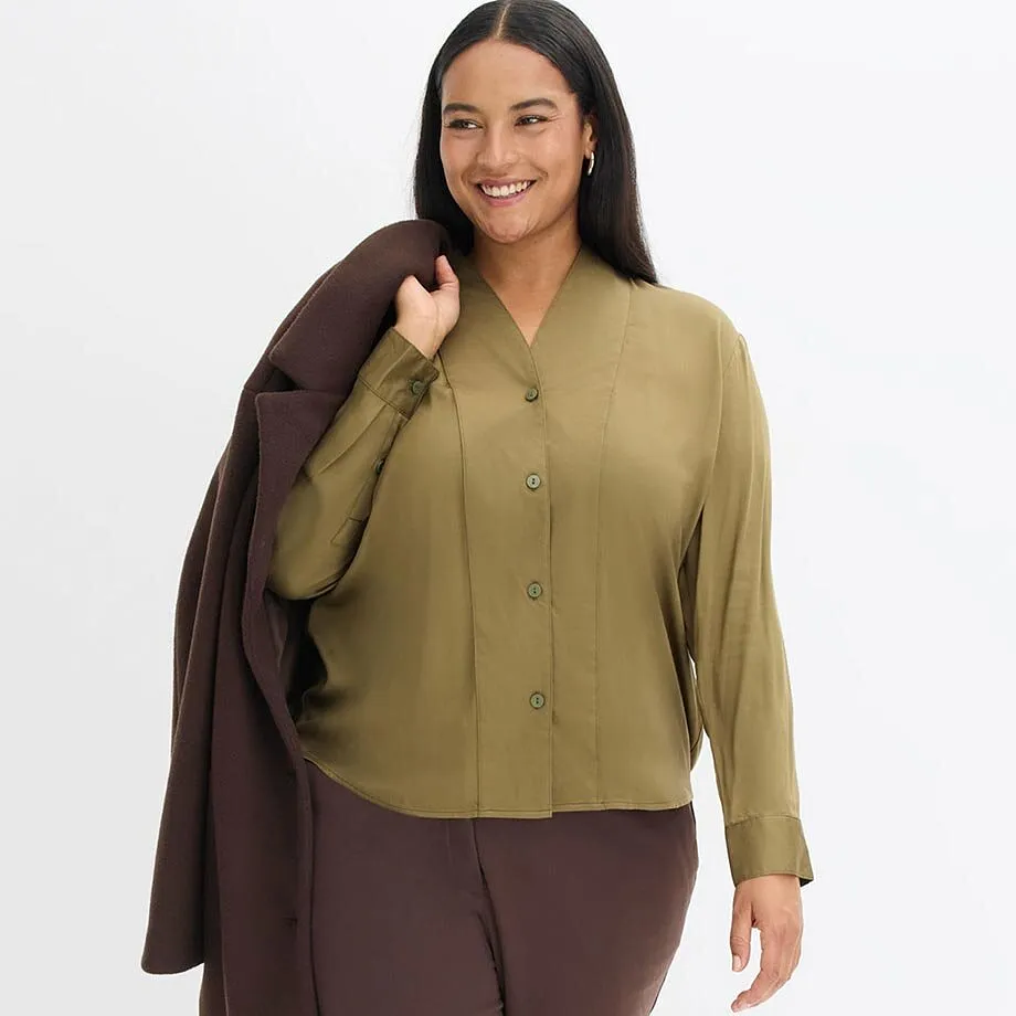 Kombination aus olivgrüner Bluse und braunem Mantel. 