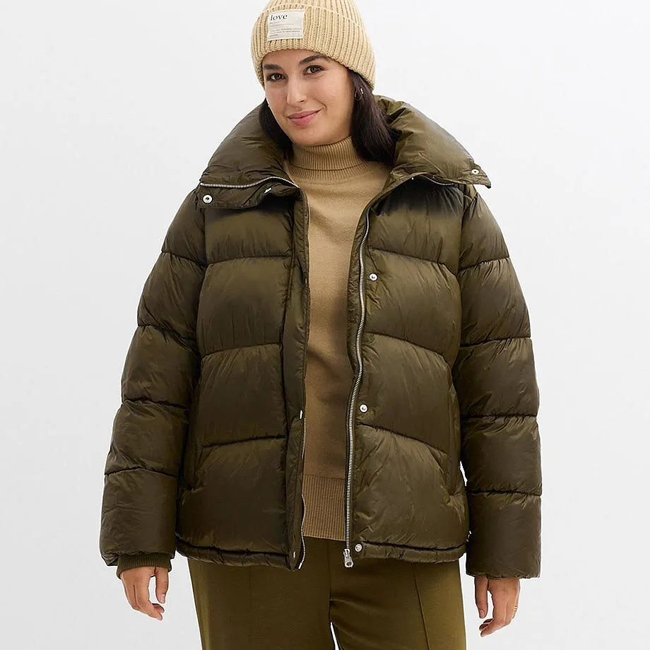 Warme Daunenjacke in Olivgrün, dazu eine beige Mütze und ein heller Pullover.