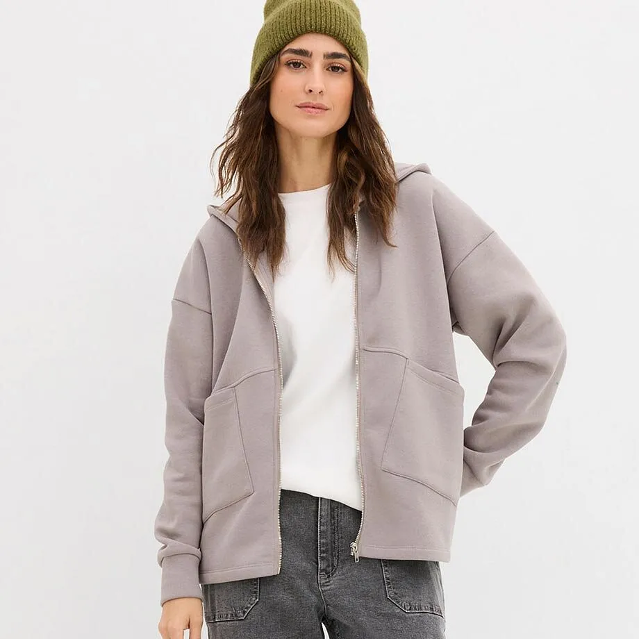 T-shirt blanc et gilet sweat-shirt gris sur un jean gris.