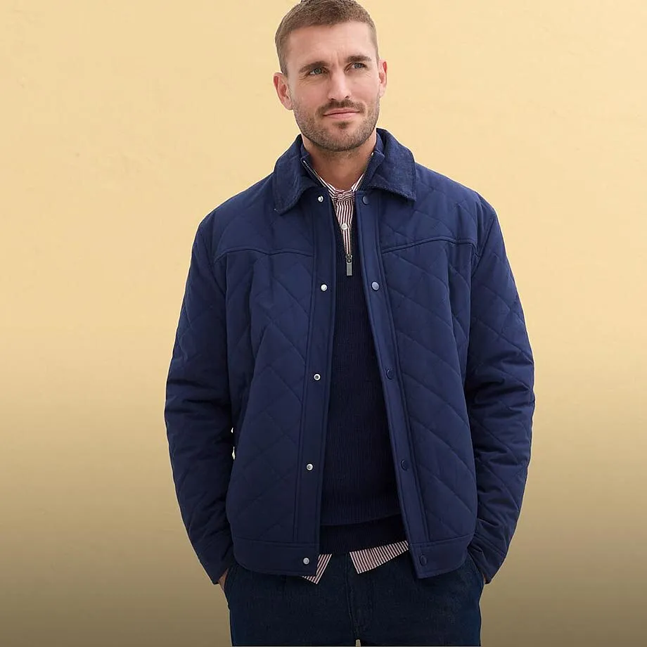 Blau-graue Steppjacke, helles T-Shirt, Jeans und wei&szlig;er Baseballkappe.