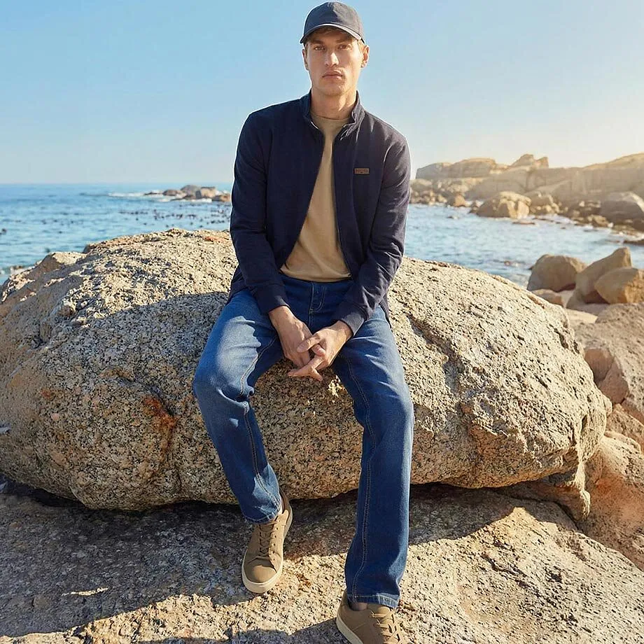 Blaue Jacke, beiges Shirt und Jeans f&uuml;r sonnige Tage am Meer.