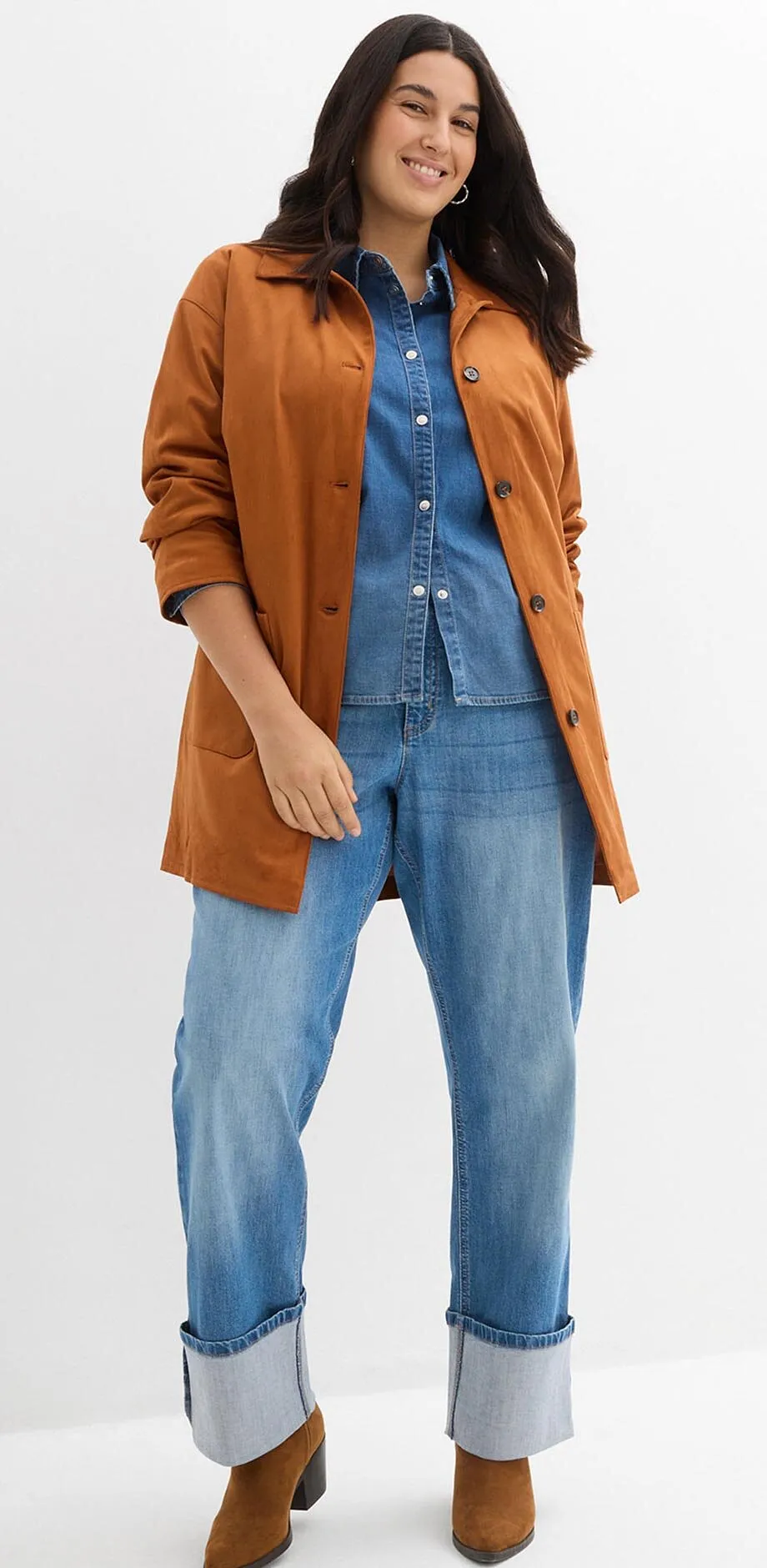 Braune Jacke &uuml;ber Jeanshemd und weiten Jeans mit Umschlag.