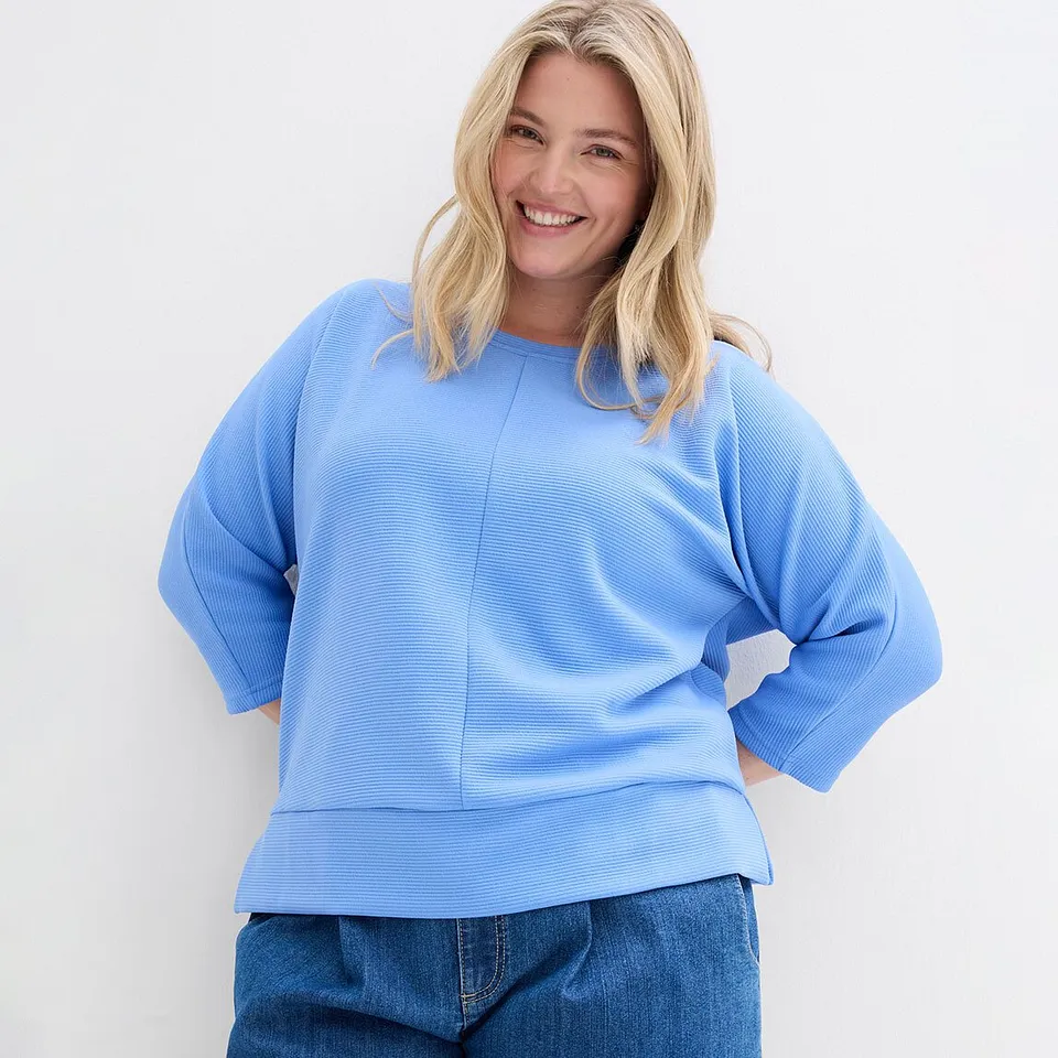 Helles Blau dominiert: Ein l&auml;ssiger Pullover mit weiten &Auml;rmeln trifft auf klassische Jeans.