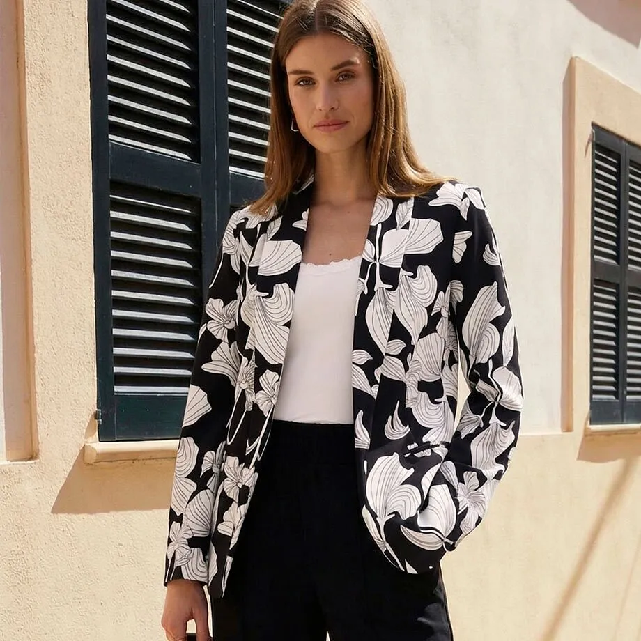 Blazer &agrave; fleurs en noir et blanc sur un top blanc et un pantalon noir.