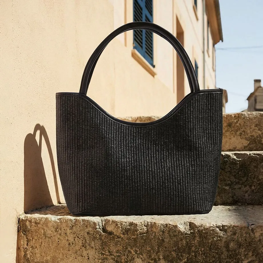 Sac noir en mati&egrave;re tress&eacute;e.