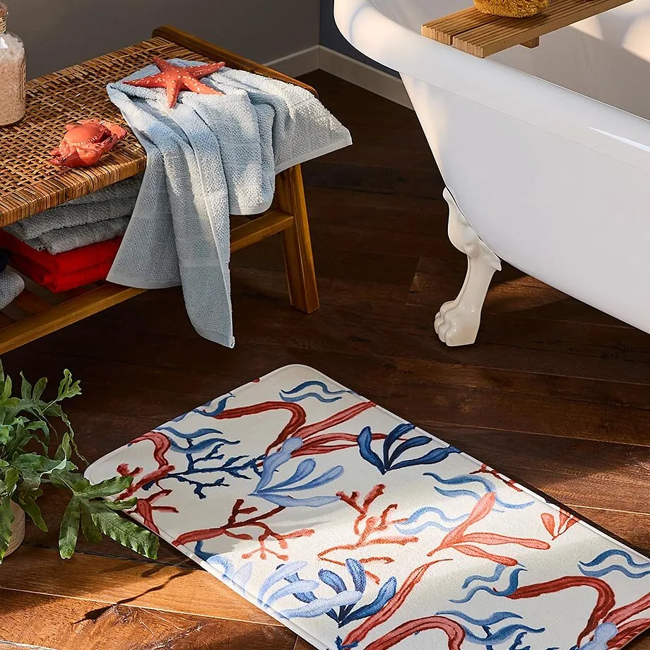 Une serviette de toilette bleu clair pos&eacute;e sur un banc en bois pr&egrave;s d'une baignoire.