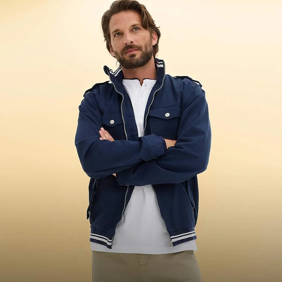 Dunkelblaue Jacke mit wei&szlig;en Akzenten &uuml;ber einem schlichten wei&szlig;en Shirt.