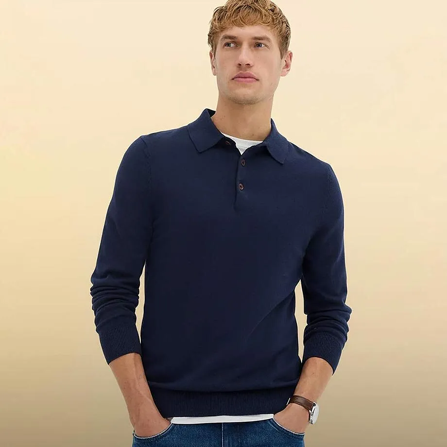 Eleganter dunkelblauer Pullover mit Kragen. Klassische blaue Jeans.