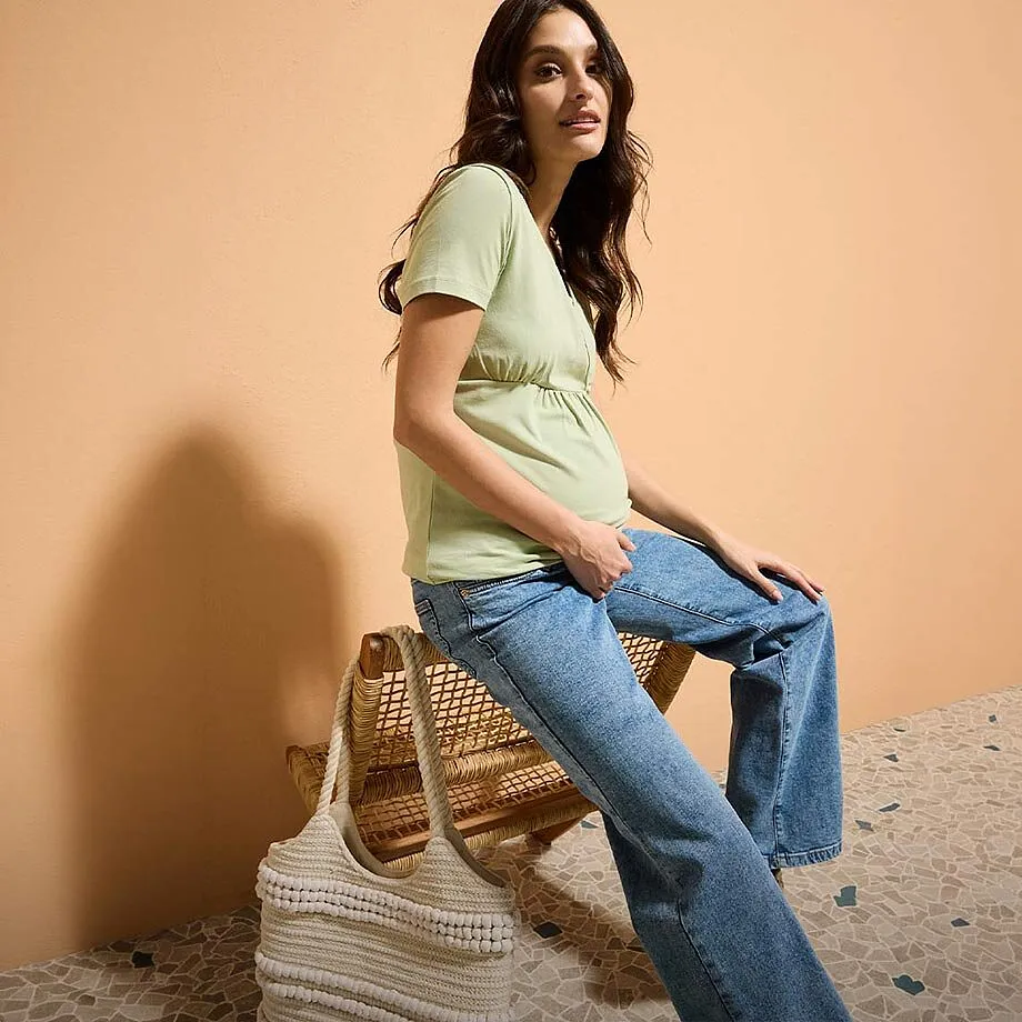 T-shirt vert clair pour femme enceinte, jean et sac tiss&eacute;.
