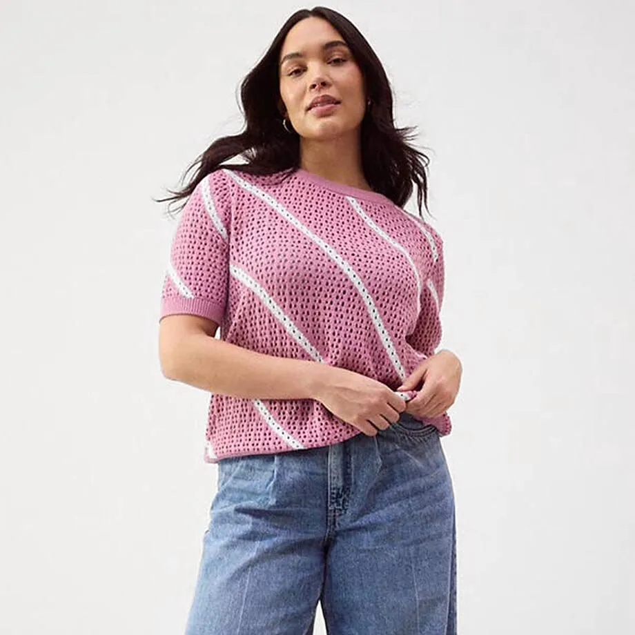 Lockerer Strickpullover in Rosa, kombiniert mit weit geschnittener Jeans.